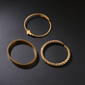 Three-piece gold men's bangle set featuring cross charm and metal mesh textures
