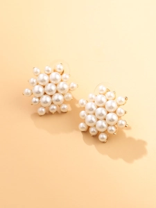 Gros plan de boucles d'oreilles élégantes en grappe de perles avec base dorée
