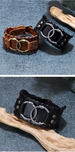 Close-up of vintage wide leather bracelets with metal snake buckle and braided edge detail