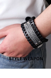 Close-up of vintage braided leather bracelet with runic engraved metal plates and rivets