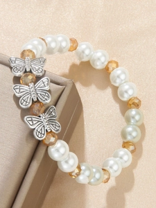Detailed shot of pearl bracelet with amber crystal beads and vintage silver butterflies