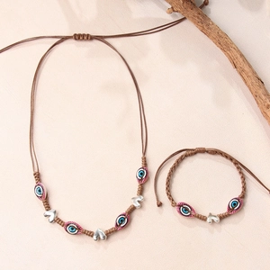 Parure bohème avec perles œil porte-bonheur et pendentifs cœur sur cordon tressé
