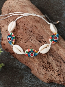 Detail of handmade bohemian shell bracelet with colorful evil eye beads on wood