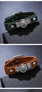 Close-up of vintage punk leather bracelets with skull and wrench charms in green and brown