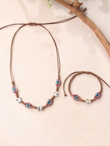 Vue détaillée du collier et bracelet bohème tressés avec œil maléfique et breloques cœur