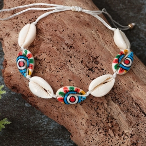 Bohemian natural seashell bracelet with colorful evil eye beads on wood display