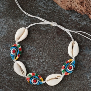 Handmade shell bracelet with colorful evil eye patterns on natural white cowrie shells