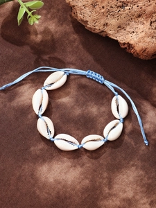 Close-up of bohemian shell anklet with blue wax cord and adjustable sliding knot