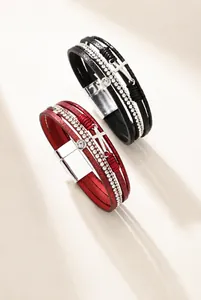 Detailansicht der mehrlagigen Lederarmbänder mit Strass, Kreuzanhänger und Magnetverschluss