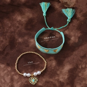 Detail showing two-piece heart bracelet set with size measurements on textured fabric