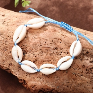 Handmade seashell anklet with blue wax cord for bohemian beach style on wood surface
