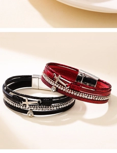 Detail von mehrlagigen Lederarmbändern mit Strass-Kreuz und Magnetverschluss aus Metall