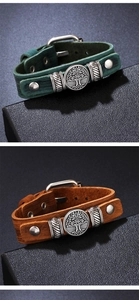 Close-up of tree of life alloy emblem and buckle on vintage adjustable leather bracelet