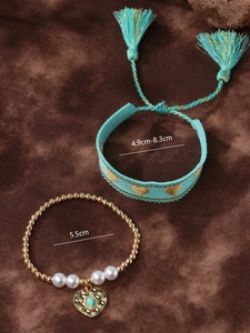 Detailed view of bohemian turquoise heart woven bracelet and beaded pearl set