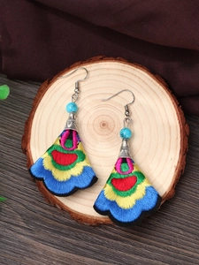 Detail of fan-shaped ethnic embroidered earrings with colorful silk patterns and blue beads