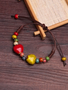 Macro detail of handmade ethnic ceramic bracelet with colorful beads and braided rope