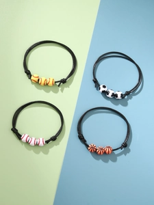 Dettaglio di quattro braccialetti sportivi intrecciati con perline di calcio, basket e baseball