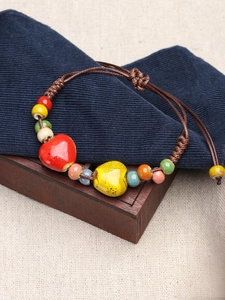 Detail of colorful ceramic bead bracelet with heart charms and adjustable cord