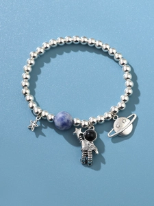 Détail du bracelet en perles d'argent S925 avec charms astronaute, étoile et Saturne