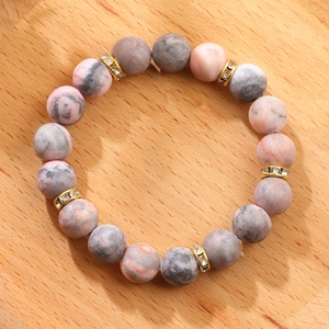 Detailed view of beaded bracelet with pink marble stones and sparkling gold spacers