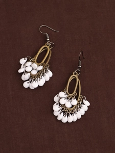 Detail of vintage bohemian tassel earrings with bronze metal and white pearly beads