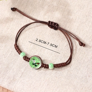 Handmade brown braided rope bracelet with dried green flower bead and butterfly charm