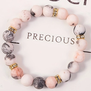 Pink quartz and zebra stone beaded yoga bracelet with crystal spacers on display