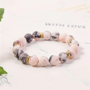 Pink and zebra jasper beaded bracelet with crystal-studded gold spacers on a gift card
