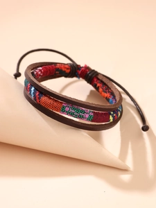 Detail eines mehrlagigen Vintage-Lederarmbands mit bunten Webmustern und verstellbarer Kordel