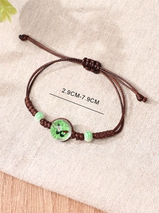 Detail of adjustable brown woven rope bracelet with green butterfly glass pendant and beads