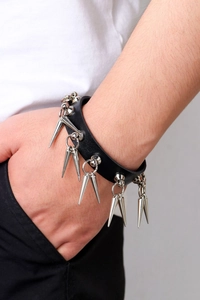 Détail d'un bracelet punk en cuir avec des pointes en métal argenté et texture grainée