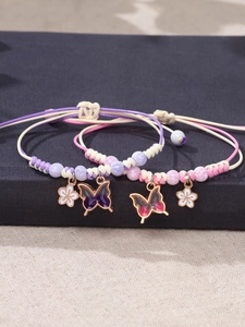Detail of woven rope bracelets with enamel butterfly charms and floral accents