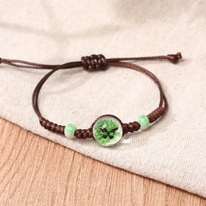 Handmade woven cord bracelet with ceramic beads and a crystal butterfly charm pendant