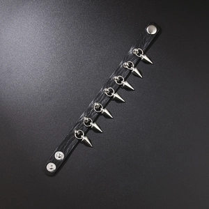 Close-up of black leather punk bracelet with silver conical spikes and snap buttons
