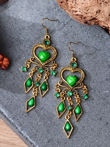 Detail of bohemian heart earrings with green marble stones and gold fringe tassels