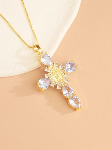 Close-up of golden cross pendant with Virgin Mary relief and clear zircon stones