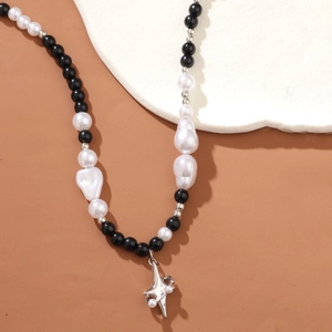 Hip hop black and white bead necklace with silver cross star pendant on stone display