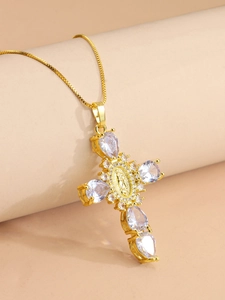 Detail of gold cross pendant with pear-shaped stones and a central religious relief