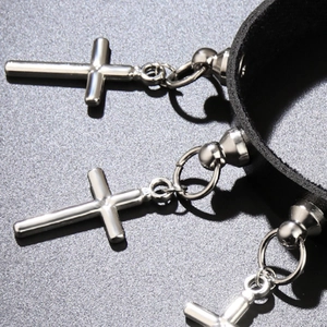 Gros plan d'un ras de cou gothique en cuir noir avec trois pendentifs croix en argent