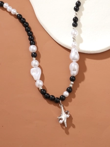 Detailed shot of mixed black beads and baroque pearls with a silver star pendant