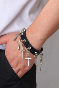 Détail d'un collier choker en cuir noir avec croix argentées et clous en métal