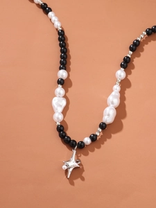 Close-up of mixed pearl and black bead necklace with a silver star pendant