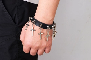 Détail d'un bracelet gothique punk en cuir noir avec pendentifs croix en métal
