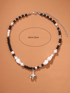 Detail of beaded necklace with black beads and white pearls plus star pendant