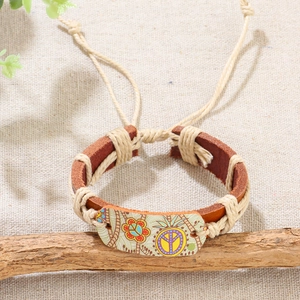 Bracciale artigianale in pelle intrecciata con ciondolo simbolo della pace su legno