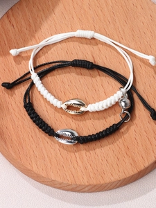 Detail of magnetic braided couple bracelets with black and white shell charms