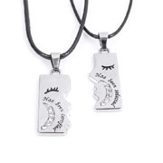 Macro view of silver couple's puzzle necklaces with engraved text and small crystals