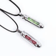 Detail of capsule pendant necklaces inspired by virus vials with red and green spirals
