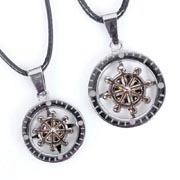 Close-up of dual-tone ship wheel pendants with silver outer ring and black wax cord