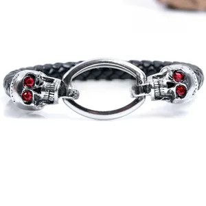Close-up of punk braided leather bracelet with silver skull charms and red crystal eyes